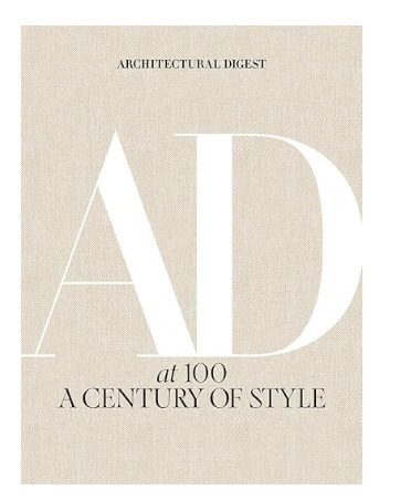 Architectural Digest at 100 coffee table book featuring a neutral linen cover with large AD typography.