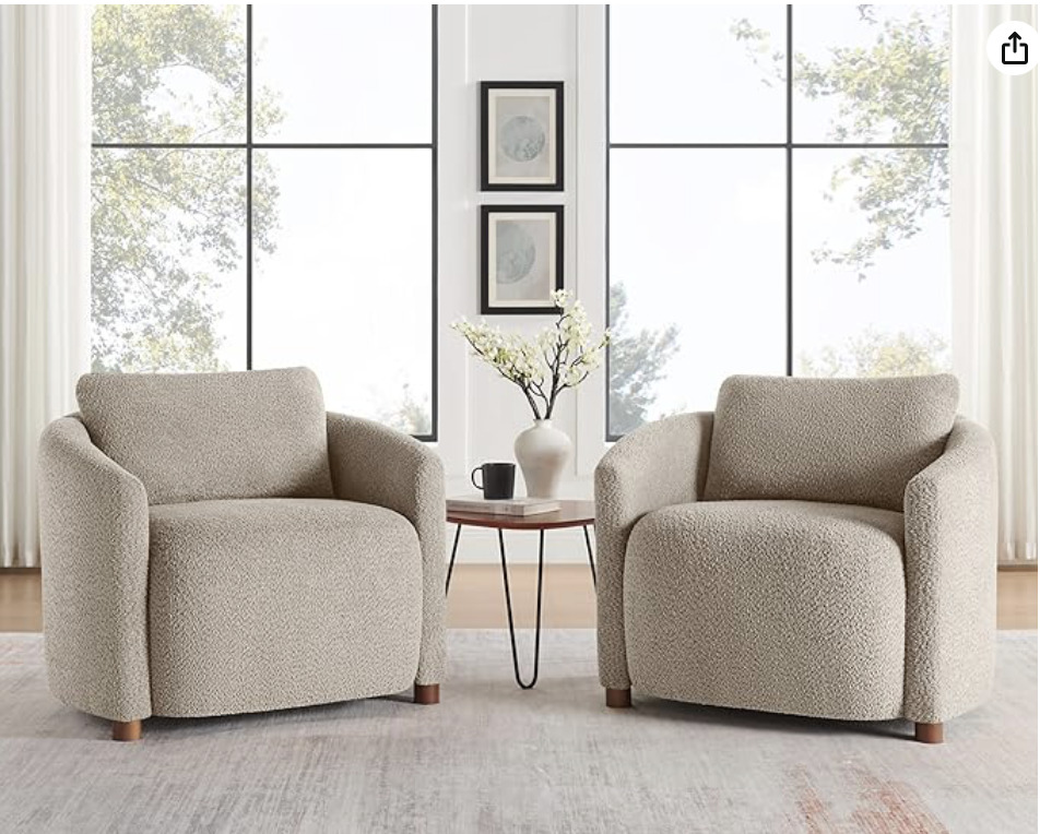 Neutral boucle accent chairs styled with a small drink table in an organic modern living room setting.