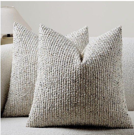 Cream and grey textured boucle throw pillow cover styled on a sofa in an organic modern living room.