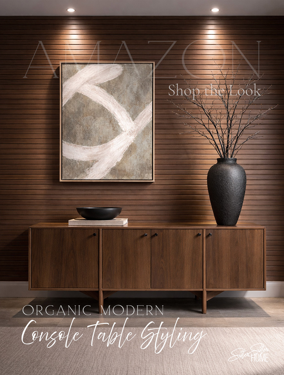 Organic modern console table styling with walnut sideboard, black vase with branches, abstract wall art, and neutral flatweave rug