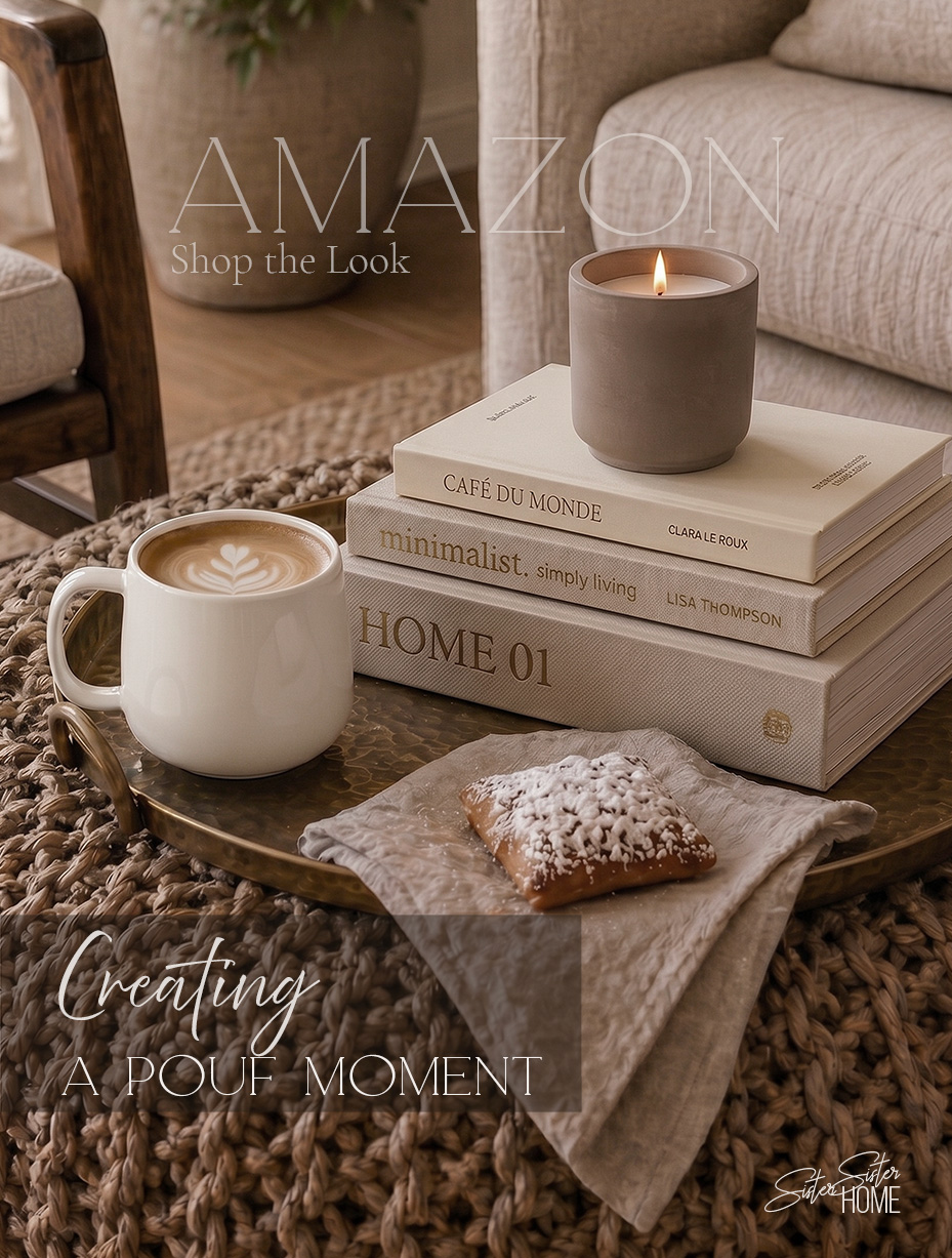 Organic modern pouf ottoman styled with brass tray, coffee, candle, neutral books and linen napkin in a warm living room