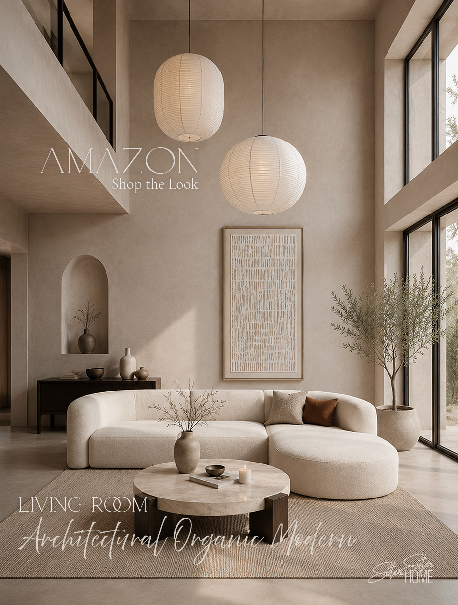 Architectural organic modern living room with a curved cream sofa, round wood travertine-look coffee table, pendant lanterns, and neutral abstract wall art.