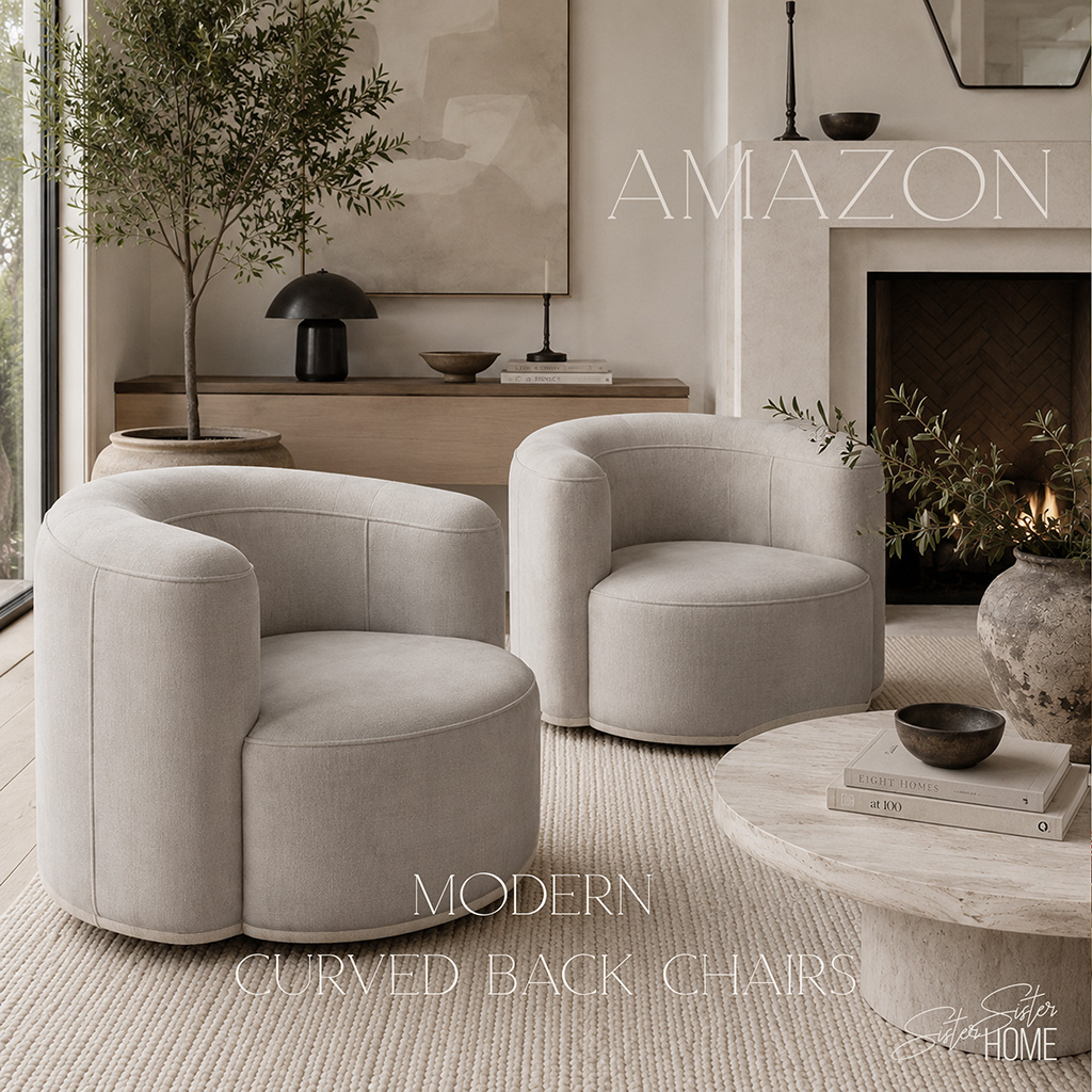 Modern curved back chairs styled in a warm organic living room with neutral decor, textured rug, stone coffee table, and fireplace.