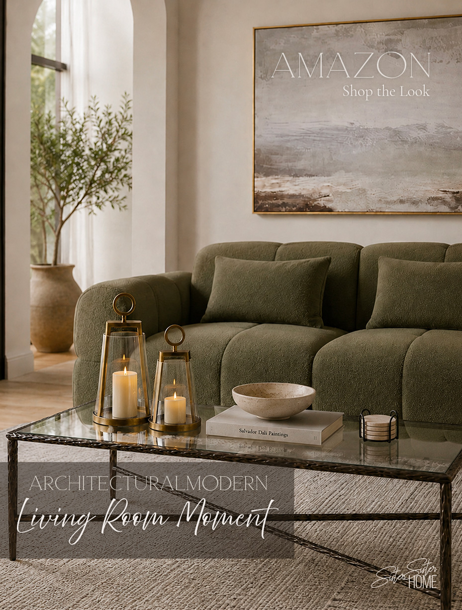 Architectural modern living room with an olive green sofa, glass coffee table, brass lanterns, travertine bowl, and neutral textured rug
