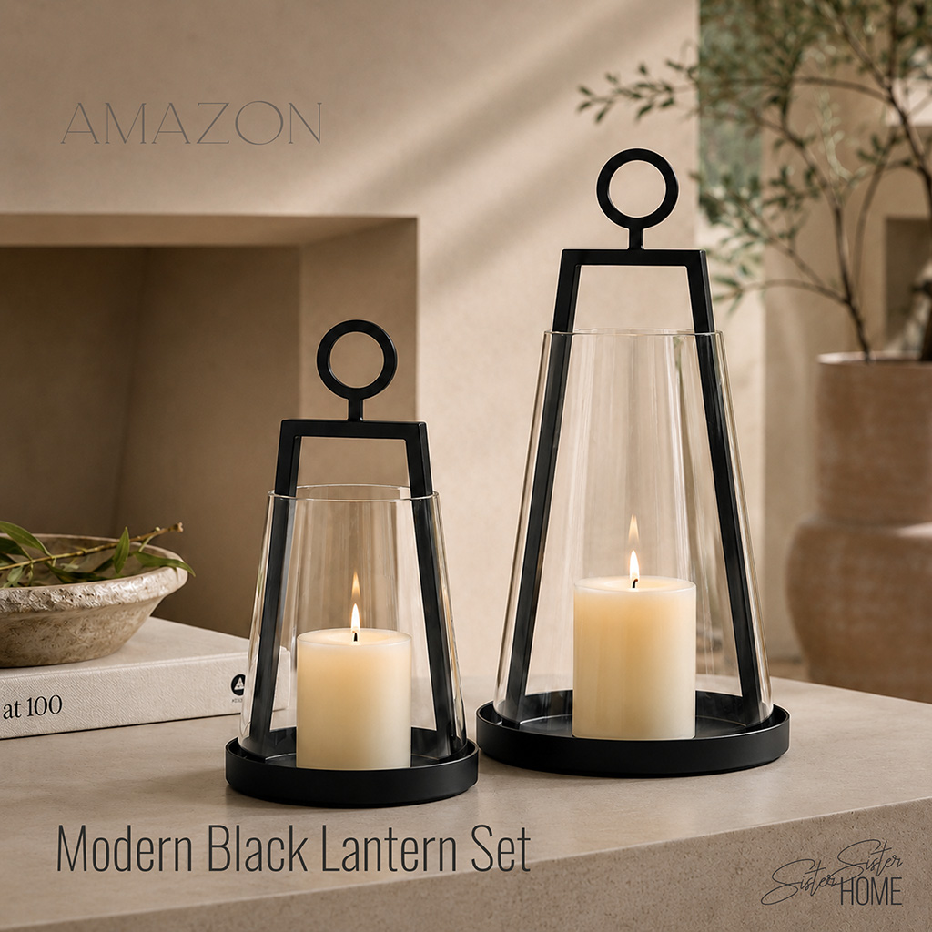 Two black metal and glass lantern candle holders styled with ivory pillar candles in a warm organic modern interior